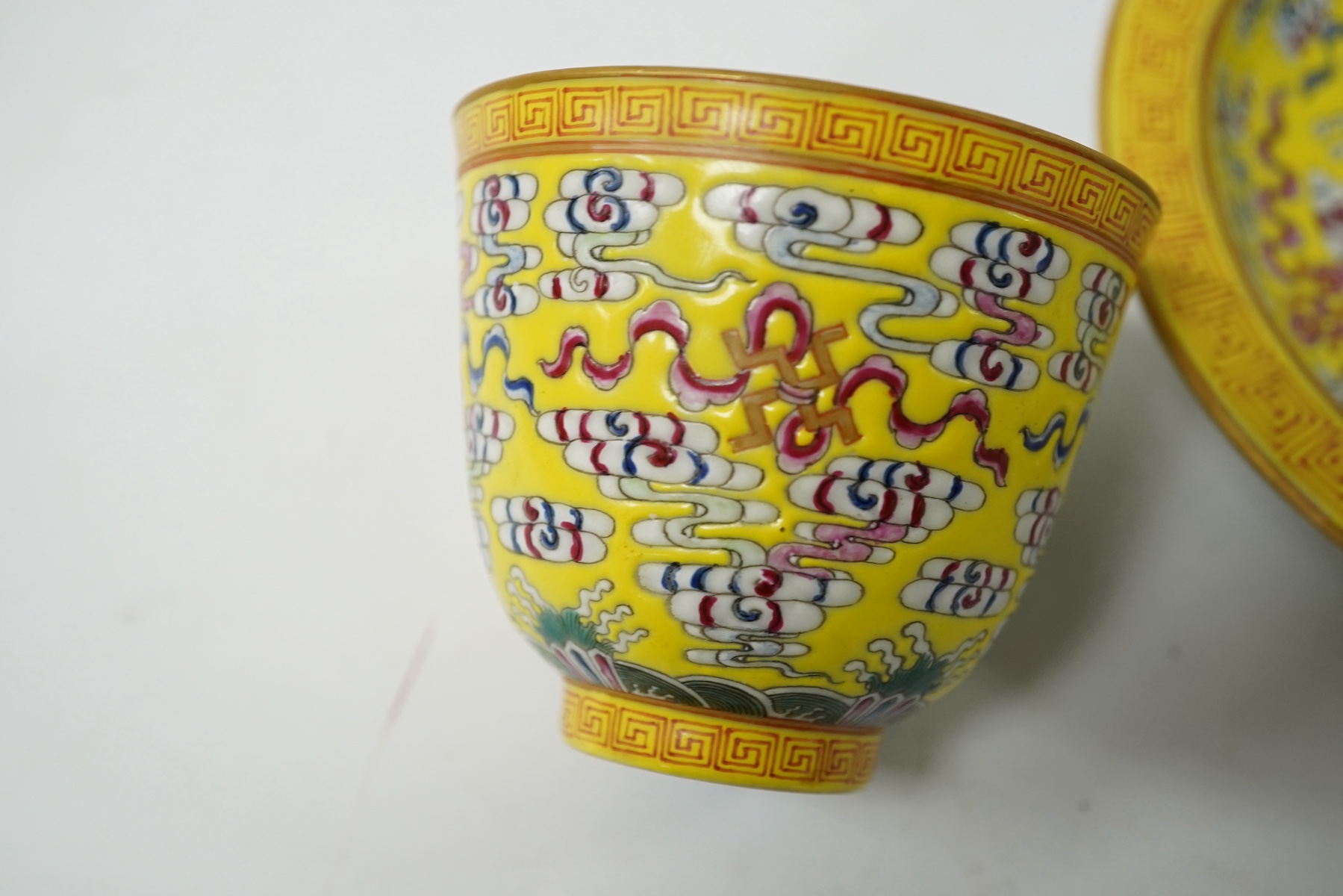 A Chinese porcelain yellow-ground tea cup and saucer, 13cm diameter. Condition - good